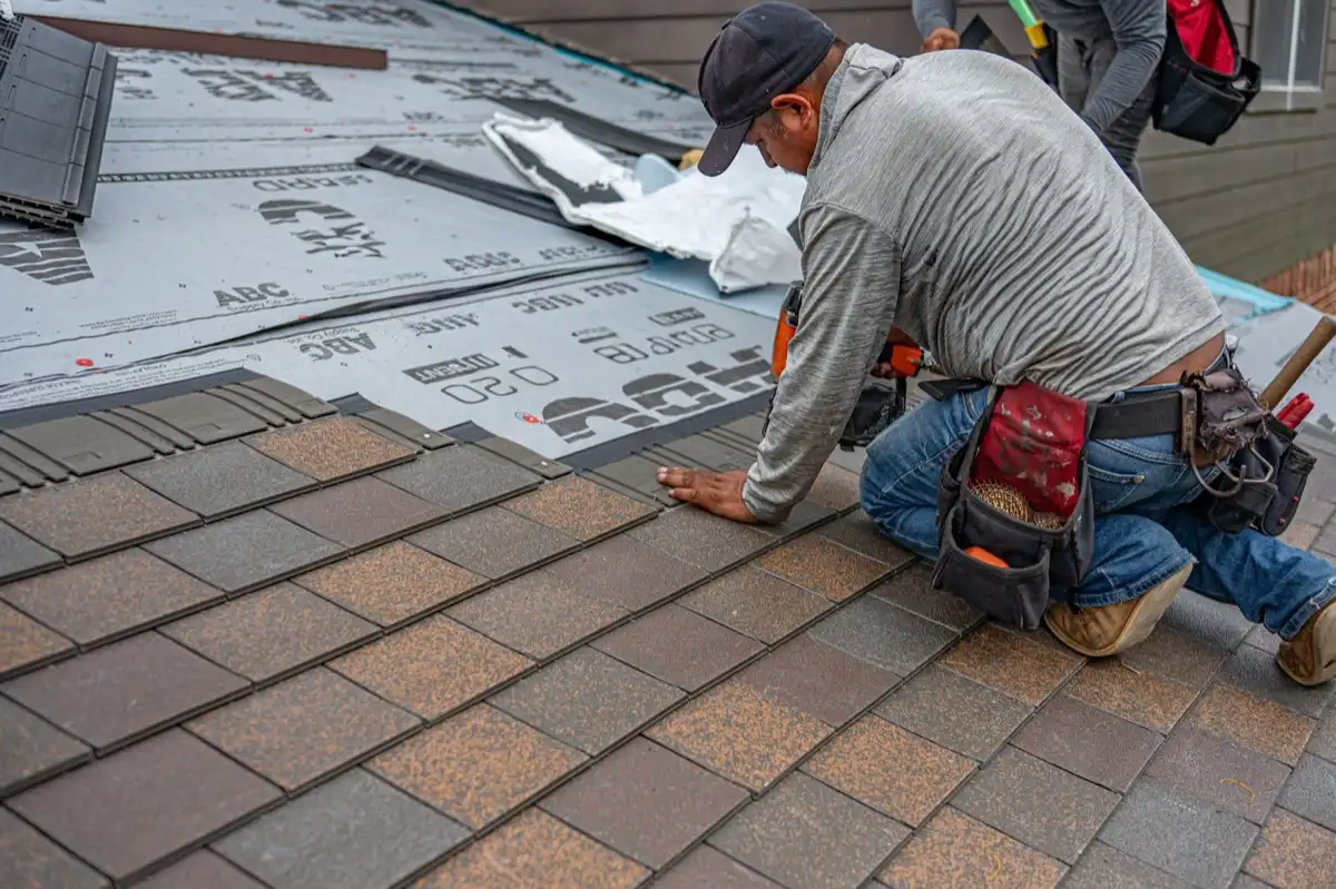 Roofing installer fastening shingles over new underlayment in Tigard, OR